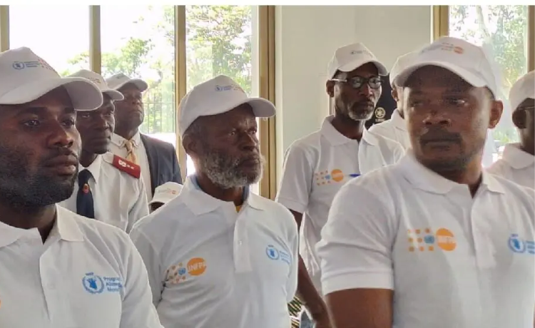  A group of men stand in a room wearing white hats and polo shirts.